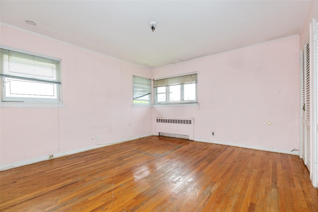 11 Webb Hill Rd, Great Neck, NY 11020 - empty room featuring radiator heating unit, hardwood / wood-style flooring, and a pendent fire sprinkler