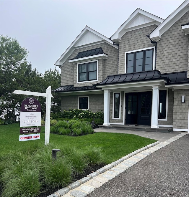 49 Shore Dr S, Copiague, NY 11726 - view of front of home with a standing seam roof, a front yard, and a metal roof