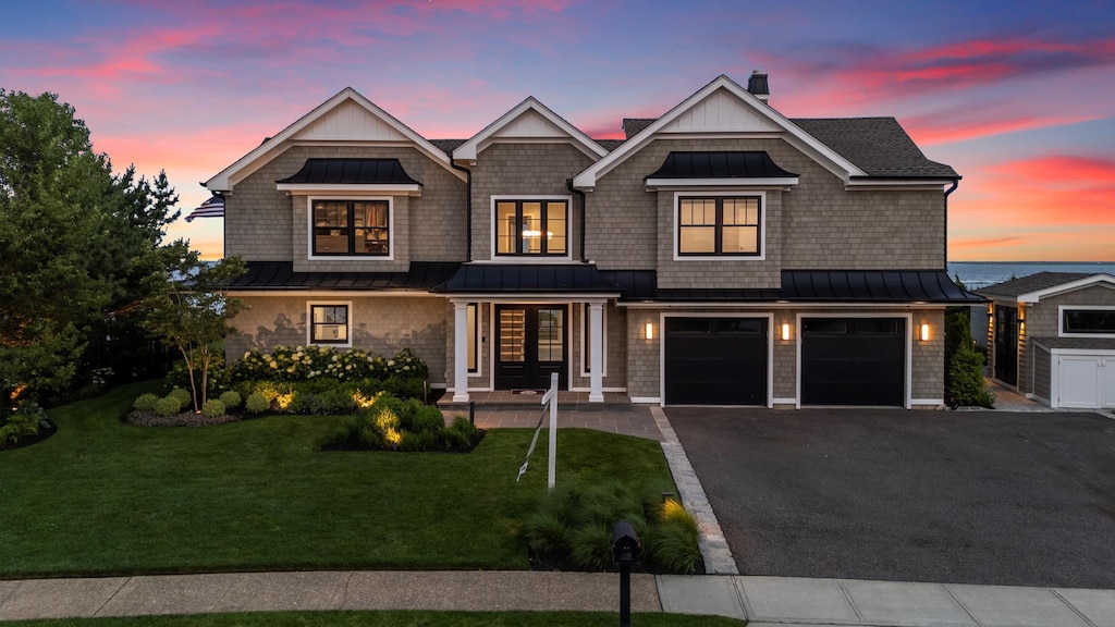 49 Shore Dr S, Copiague, NY 11726 - shingle-style home with a standing seam roof, asphalt driveway, a metal roof, an attached garage, and a front yard