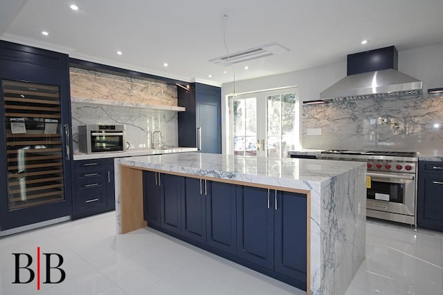 82 Piedmont Ave, Staten Island, NY 10305 - kitchen with wall chimney exhaust hood, stainless steel appliances, beverage cooler, blue cabinetry, and a spacious island
