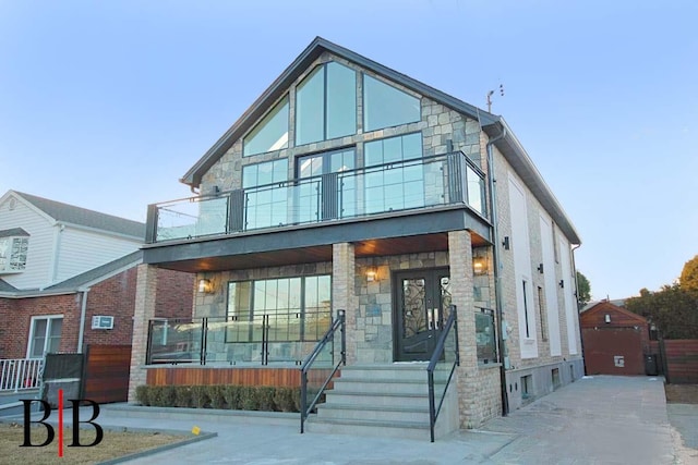 82 Piedmont Ave, Staten Island, NY 10305 - modern home featuring stone siding, a balcony, and covered porch