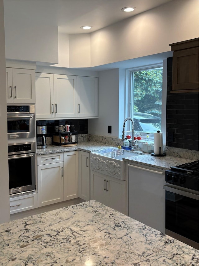 84 Highview Ave, Nanuet, NY 10954 - kitchen with range with gas cooktop, decorative backsplash, white cabinetry, light stone countertops, and recessed lighting