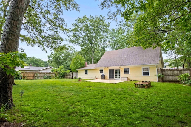 5 Seward Ln, Stony Brook, NY 11790 - back of property featuring a patio area, a fenced backyard, a chimney, and a shingled roof
