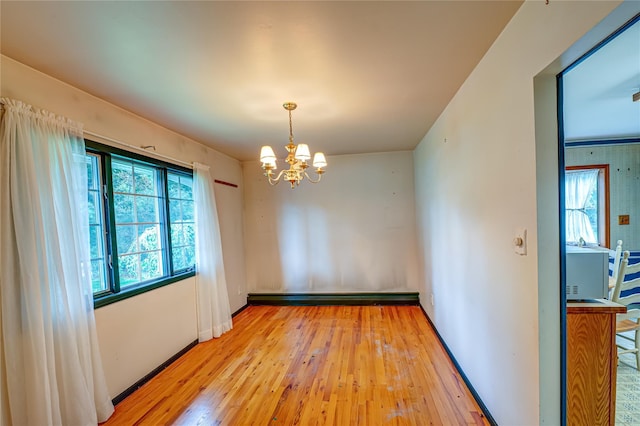 26 Village Ln, Hauppauge, NY 11788 - empty room with baseboard heating, a chandelier, and light wood-style flooring