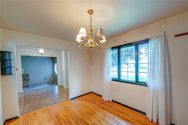 26 Village Ln, Hauppauge, NY 11788 - spare room featuring a chandelier and light wood-style floors