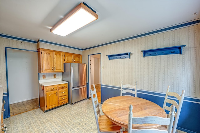 26 Village Ln, Hauppauge, NY 11788 - kitchen featuring freestanding refrigerator, light countertops, and brown cabinets