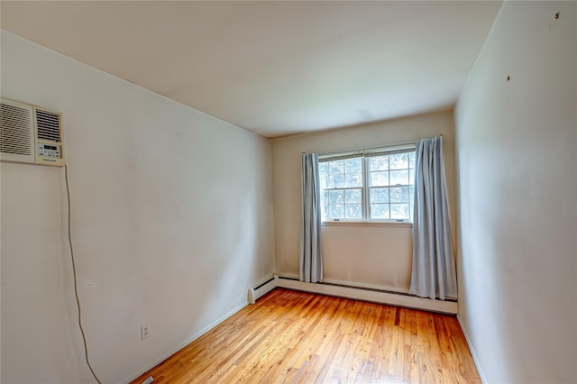 26 Village Ln, Hauppauge, NY 11788 - unfurnished room featuring a baseboard heating unit, an AC wall unit, and light wood-type flooring