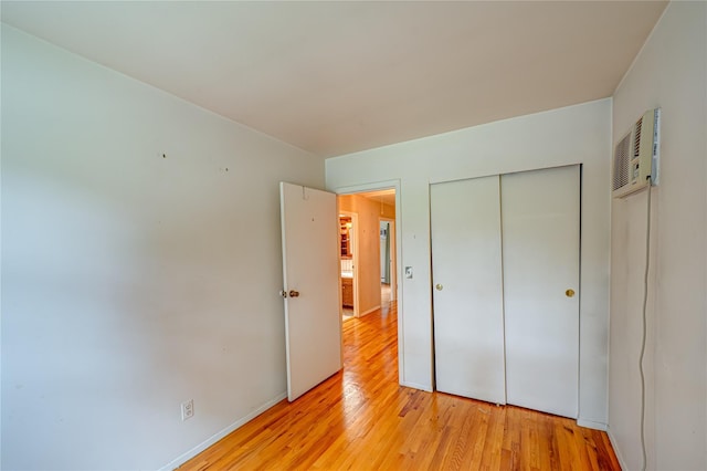 26 Village Ln, Hauppauge, NY 11788 - unfurnished bedroom featuring light wood-style flooring, a closet, and a wall mounted AC