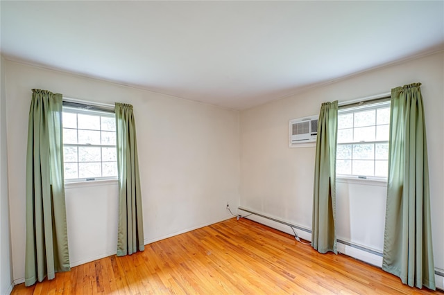 26 Village Ln, Hauppauge, NY 11788 - unfurnished room with a baseboard heating unit, healthy amount of natural light, and light wood-type flooring