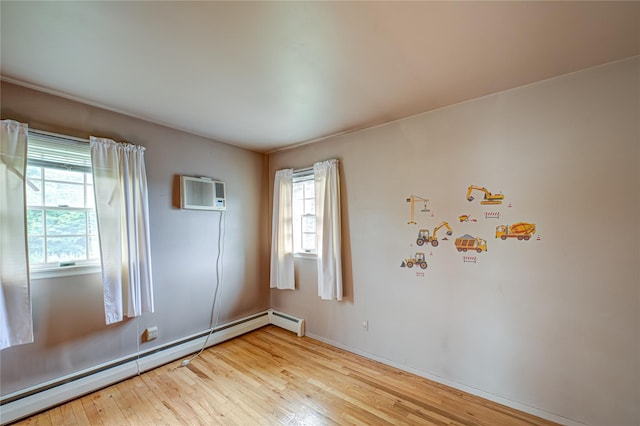 26 Village Ln, Hauppauge, NY 11788 - unfurnished room with a baseboard heating unit, light wood-type flooring, and an AC wall unit