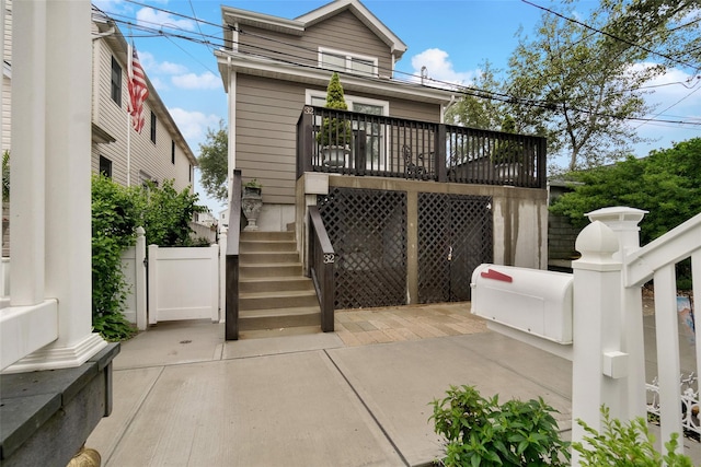 32 Janet Ln, Breezy Point, NY 11697 - back of house with stairway and a wooden deck
