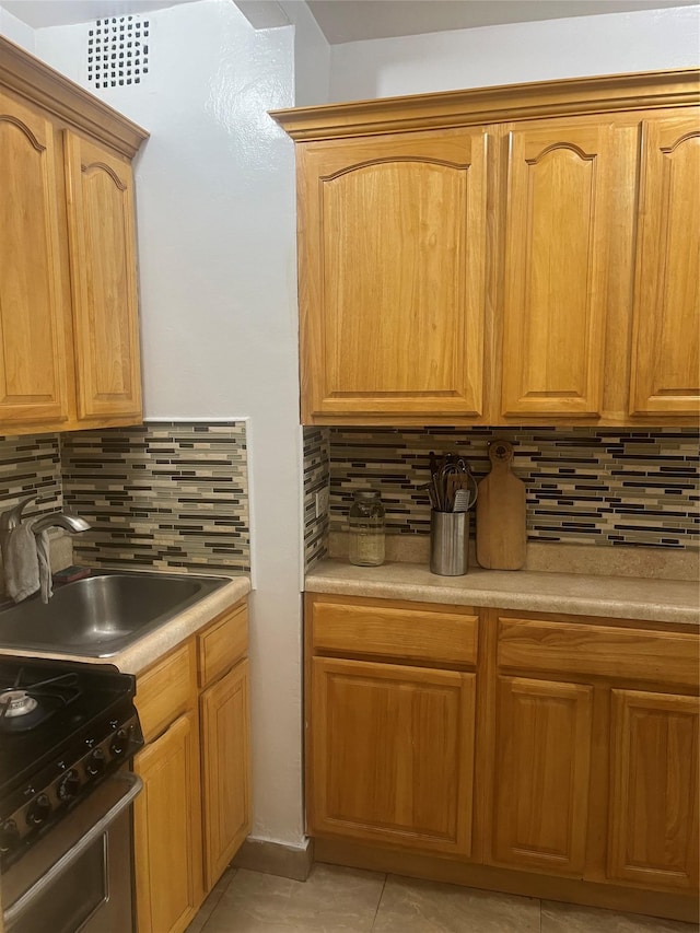 66-92 Selfridge St Unit 3J, Forest Hills, NY 11375 - kitchen featuring backsplash, gas range oven, light tile patterned flooring, and light countertops