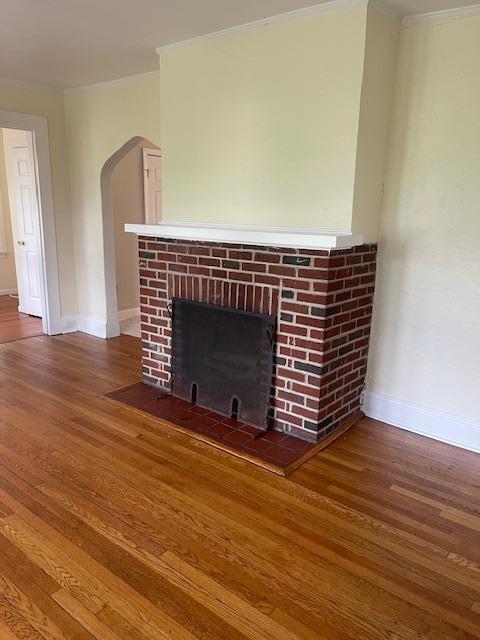 60 Hartsdale Rd, Elmsford, NY 10523 - detailed view of crown molding, a fireplace, wood finished floors, and arched walkways