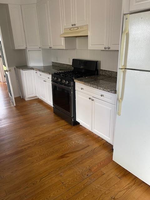 60 Hartsdale Rd, Elmsford, NY 10523 - kitchen featuring freestanding refrigerator, gas stove, under cabinet range hood, and white cabinetry