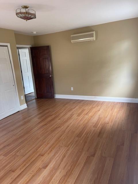 60 Hartsdale Rd, Elmsford, NY 10523 - spare room with a wall unit AC and light wood-type flooring