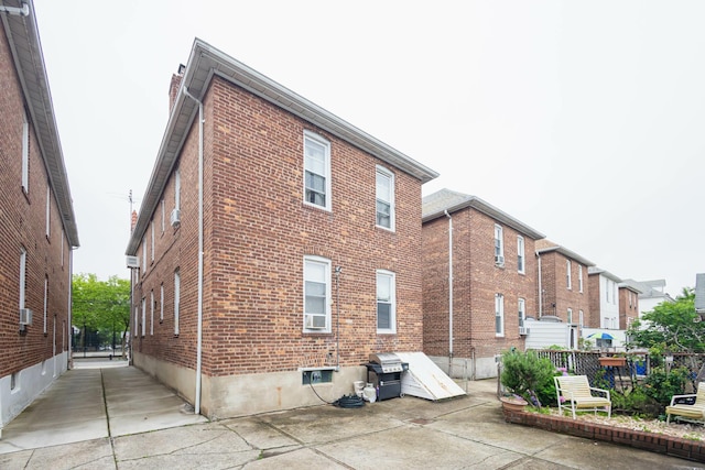 40-29 201st St Unit A, B, C, Bayside, NY 11361 - view of side of property with brick siding and a patio
