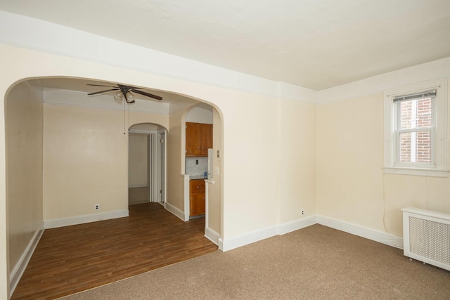 40-29 201st St Unit A, B, C, Bayside, NY 11361 - unfurnished room with radiator heating unit, arched walkways, a ceiling fan, carpet, and wood finished floors