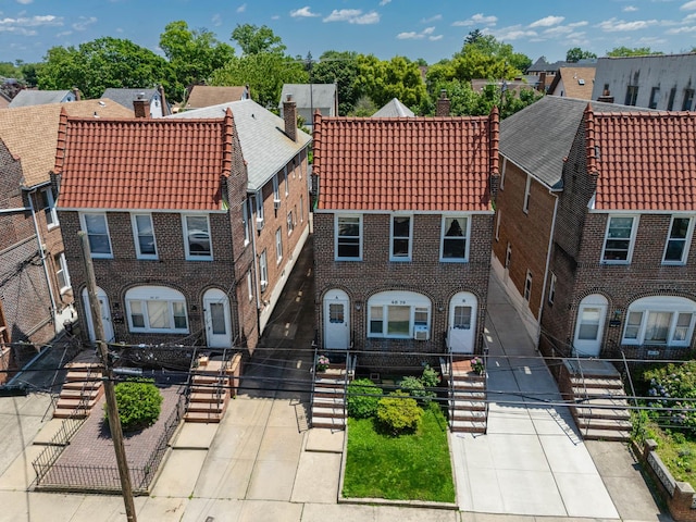 40-29 201st St Unit A, B, C, Bayside, NY 11361 - view of front of property featuring brick siding, a chimney, a tile roof, and a fenced front yard