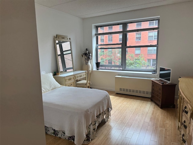 837 Washington Ave Unit 3A, Bronx, NY 10451 - bedroom featuring radiator heating unit, multiple windows, and light wood-style floors