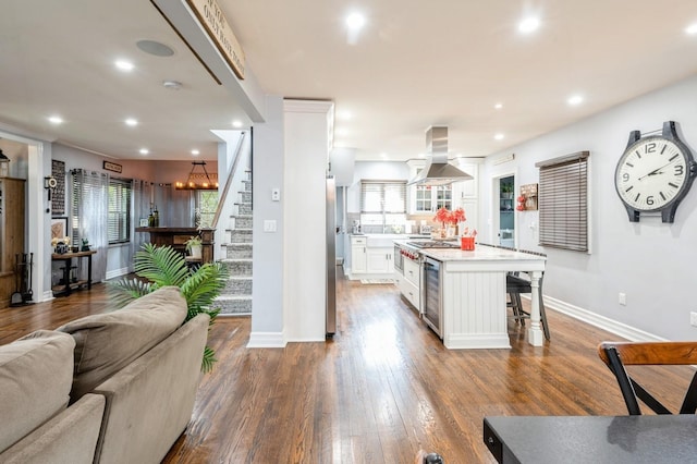 35 Irenhyl Ave, Port Chester, NY 10573 - kitchen with island exhaust hood, white cabinetry, light countertops, a breakfast bar, and recessed lighting