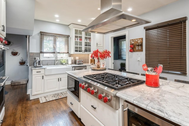 35 Irenhyl Ave, Port Chester, NY 10573 - kitchen with island exhaust hood, black microwave, stainless steel gas stovetop, wine cooler, and white cabinets