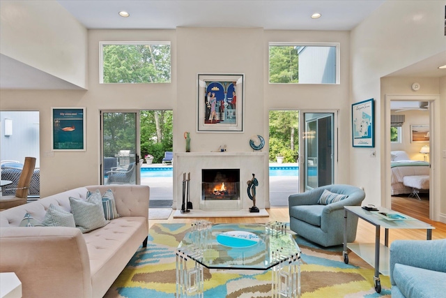 41 Park Cir, Quogue, NY 11959 - living room featuring a high ceiling, healthy amount of natural light, a premium fireplace, wood finished floors, and recessed lighting
