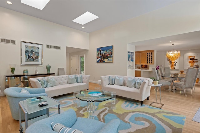 41 Park Cir, Quogue, NY 11959 - living area featuring a chandelier, a skylight, wood finished floors, recessed lighting, and a towering ceiling