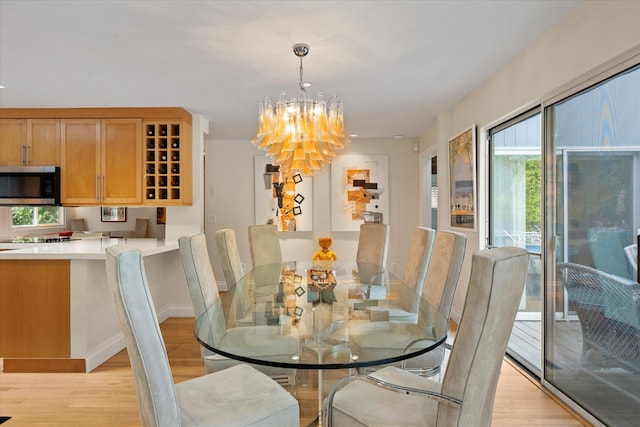 41 Park Cir, Quogue, NY 11959 - dining area featuring light wood finished floors and a chandelier