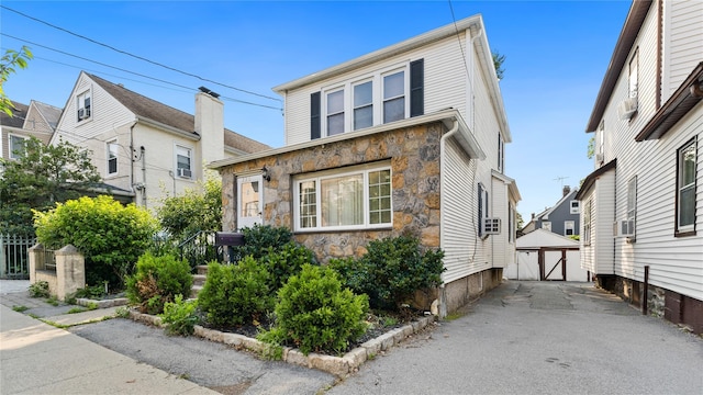 236 N High St, Mount Vernon, NY 10550 - view of front of house featuring stone siding, a garage, cooling unit, and an outbuilding