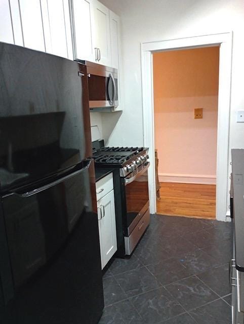 41-42 42nd St Unit 4L, Sunnyside, NY 11104 - kitchen with stainless steel appliances, white cabinets, dark tile patterned flooring, and dark countertops