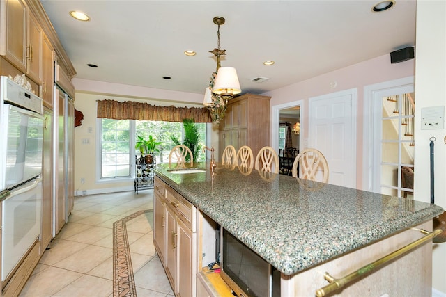 1 Ravine Rd, Great Neck, NY 11023 - kitchen featuring a kitchen island, recessed lighting, light tile patterned floors, stainless steel microwave, and dark stone counters