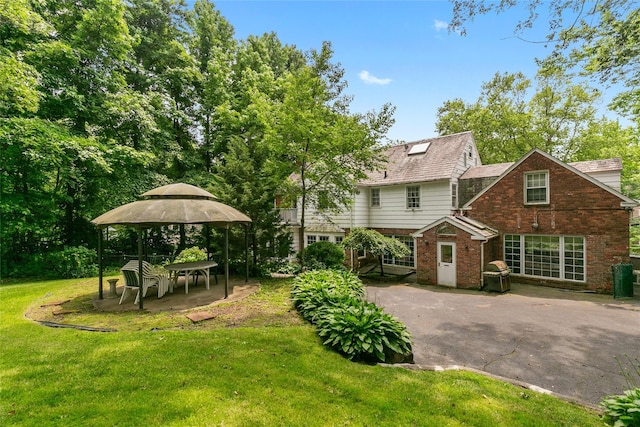 1 Ravine Rd, Great Neck, NY 11023 - back of property with a gazebo, a lawn, and brick siding