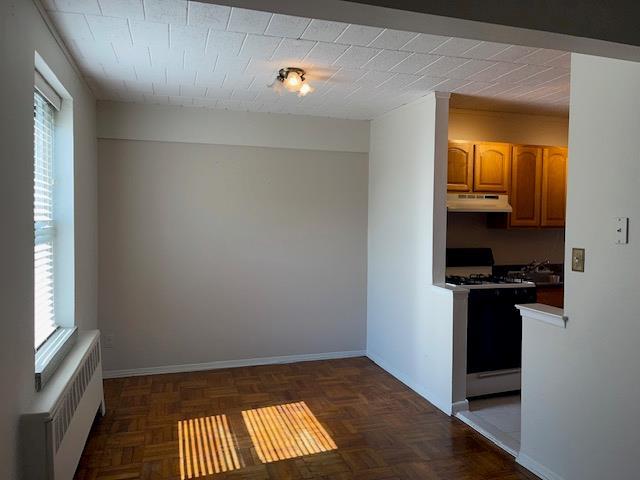 125 Main St Unit 2H, Port Washington, NY 11050 - unfurnished dining area featuring radiator and healthy amount of natural light