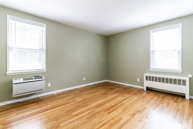 325 Palmer Ter Unit 1D, Mamaroneck, NY 10543 - unfurnished room with radiator heating unit, light wood-type flooring, plenty of natural light, and a wall unit AC