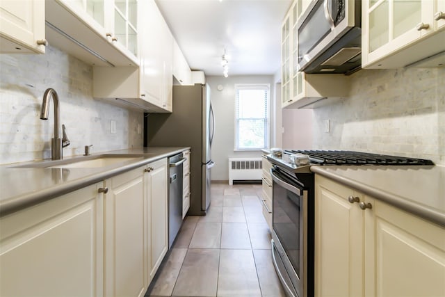 325 Palmer Ter Unit 1D, Mamaroneck, NY 10543 - kitchen featuring stainless steel appliances, radiator, decorative backsplash, and light countertops