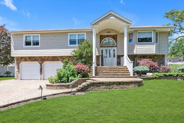 2080 Beech St, Wantagh, NY 11793 - split foyer home with stone siding, a front lawn, an attached garage, and driveway