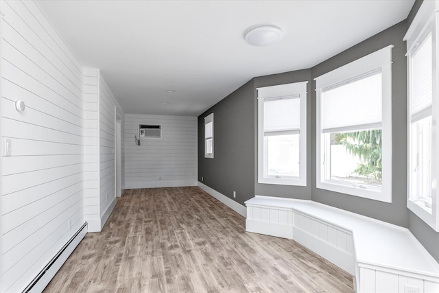 2080 Beech St, Wantagh, NY 11793 - unfurnished room featuring a baseboard heating unit, a wall unit AC, light wood-style flooring, and wooden walls