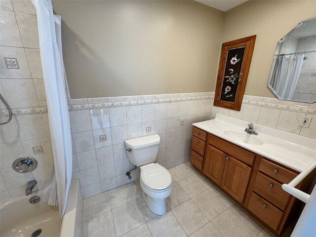 2080 Beech St, Wantagh, NY 11793 - bathroom featuring vanity, shower / bath combo with shower curtain, a wainscoted wall, tile walls, and tile patterned flooring