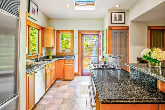 33 Ridge Rd, Ardsley, NY 10502 - kitchen featuring appliances with stainless steel finishes, a skylight, recessed lighting, dark stone counters, and light tile patterned floors