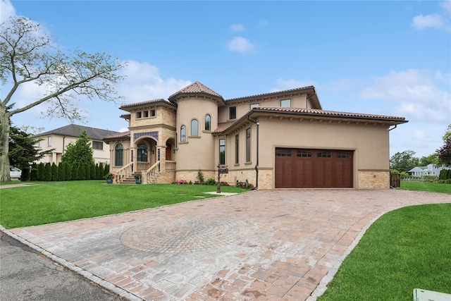 1190 Harbor Rd, Hewlett Harbor, NY 11557 - mediterranean / spanish house featuring stucco siding, decorative driveway, stone siding, a garage, and a front lawn
