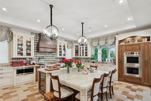 1190 Harbor Rd, Hewlett Harbor, NY 11557 - dining space with wine cooler, a tray ceiling, a chandelier, recessed lighting, and light flooring