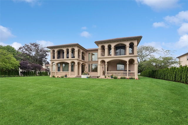 1190 Harbor Rd, Hewlett Harbor, NY 11557 - rear view of house featuring a porch, stucco siding, a yard, and a tile roof