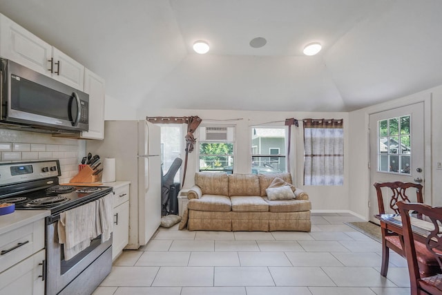 27 Dana Ave, Mastic, NY 11950 - kitchen featuring stainless steel appliances, lofted ceiling, light countertops, backsplash, and white cabinetry