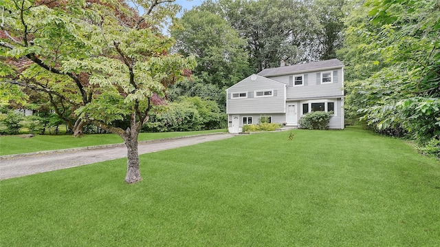 7 Kings Ln, Montrose, NY 10548 - view of front of house with driveway, an attached garage, a front lawn, and a chimney
