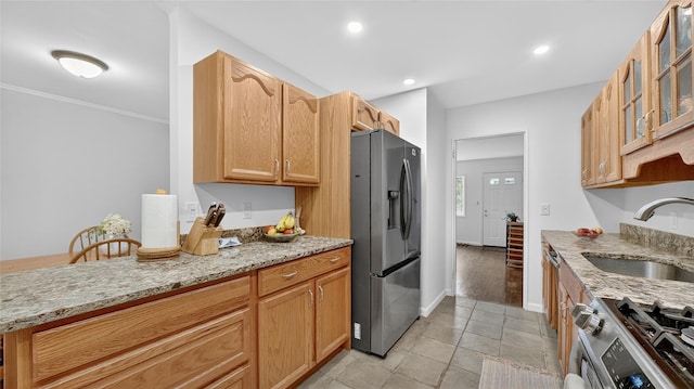 7 Kings Ln, Montrose, NY 10548 - kitchen featuring appliances with stainless steel finishes, glass insert cabinets, light stone counters, crown molding, and light tile patterned floors