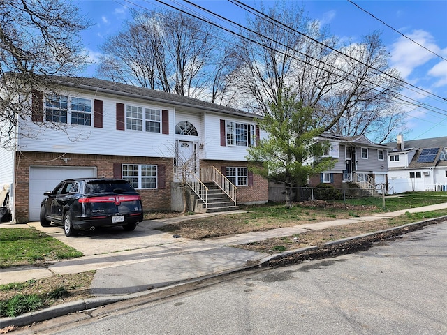 1056 E Arthur St, Uniondale, NY 11553 - bi-level home with an attached garage, brick siding, and concrete driveway