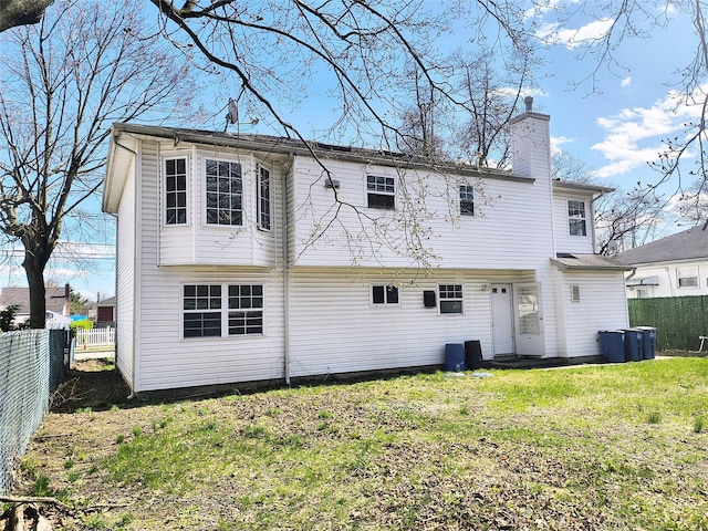 1056 E Arthur St, Uniondale, NY 11553 - back of property with a chimney and a fenced backyard