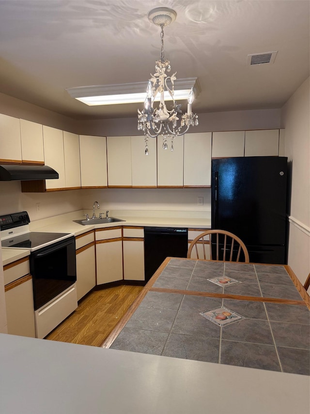 1012 Skyline Dr, Coram, NY 11727 - kitchen with black appliances, under cabinet range hood, light wood-type flooring, a chandelier, and decorative light fixtures