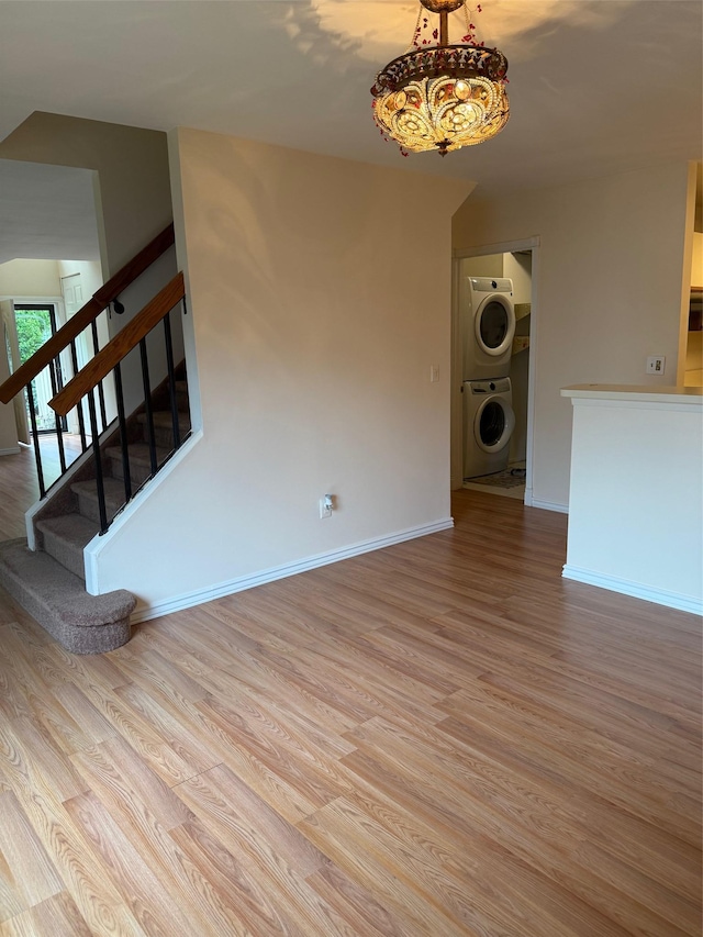1012 Skyline Dr, Coram, NY 11727 - unfurnished living room featuring stacked washer / drying machine, wood finished floors, and stairway