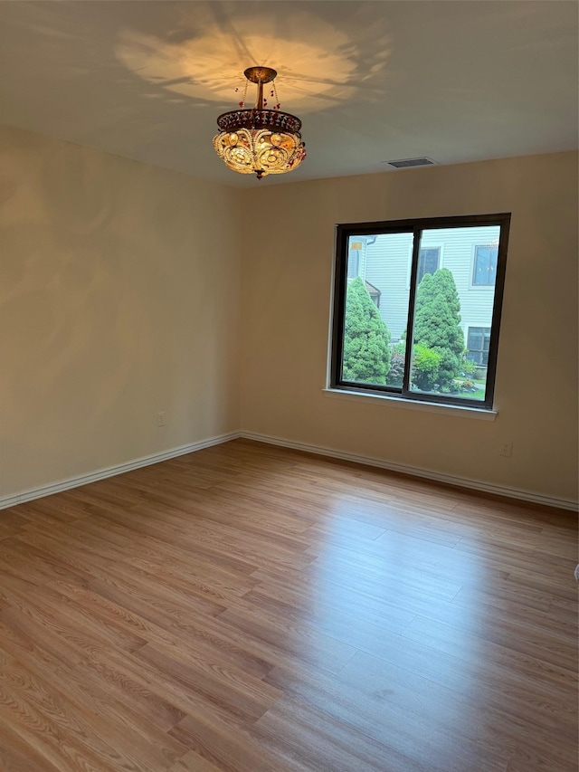 1012 Skyline Dr, Coram, NY 11727 - unfurnished room featuring wood finished floors and a chandelier